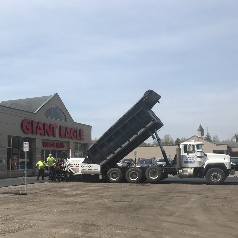 Dump truck and paver resurfacing a Giant Eagle supermarket parking lot
