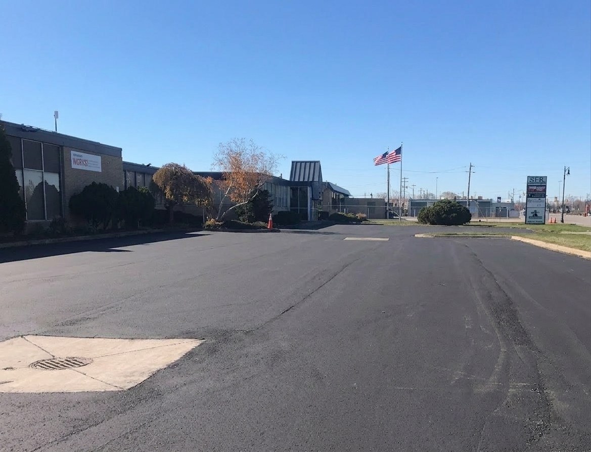 Freshly paved industrial facility lot with new asphalt